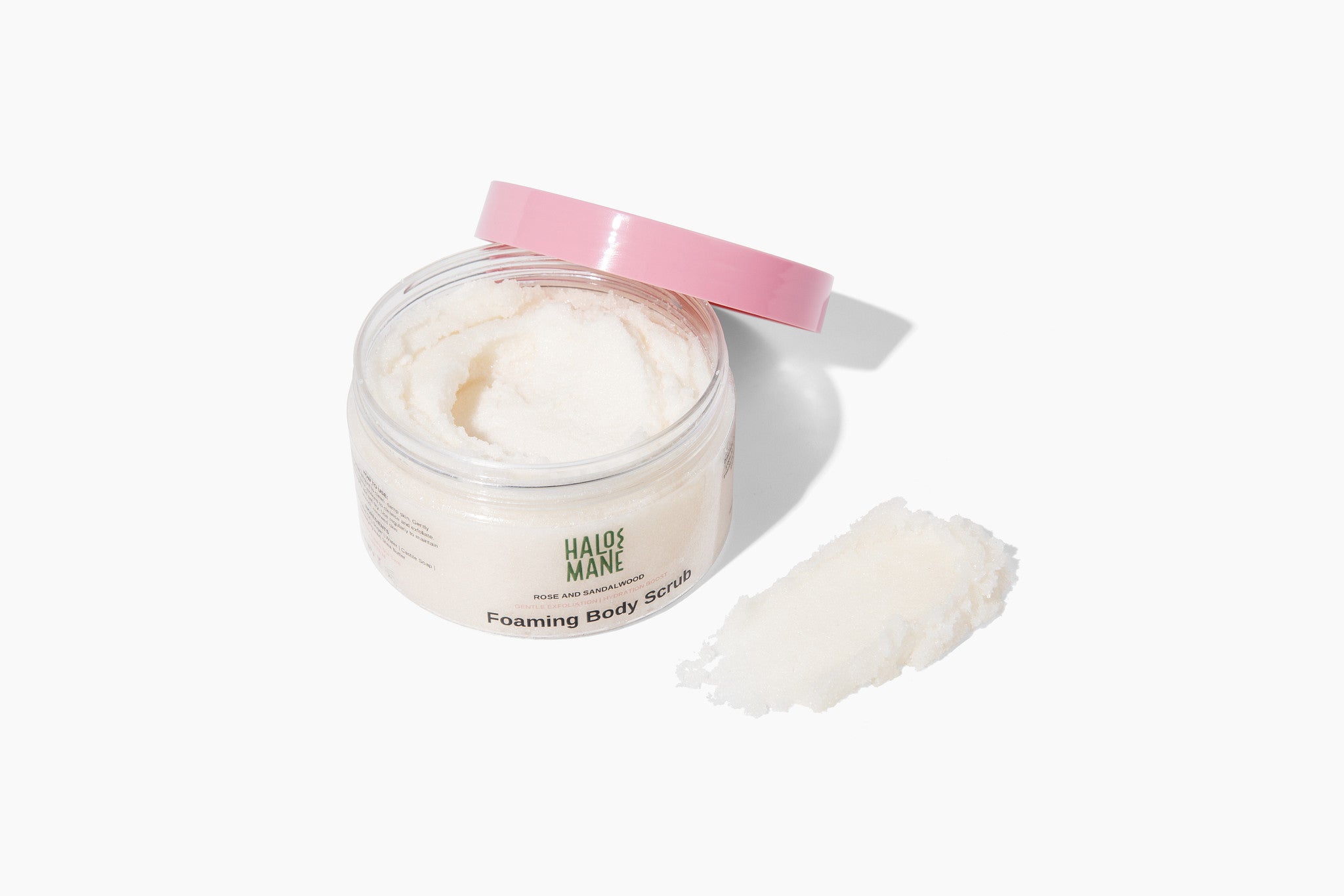 Jar of foaming body scrub with a pink lid on a white background